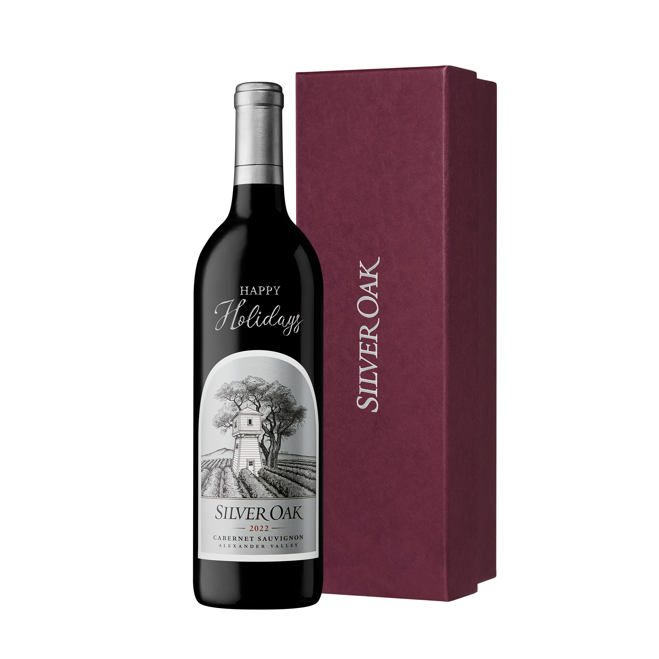 A bottle of Silver Oak Alexander Valley etched and hand painted with the message Happy Holidays, beside a burgundy gift box