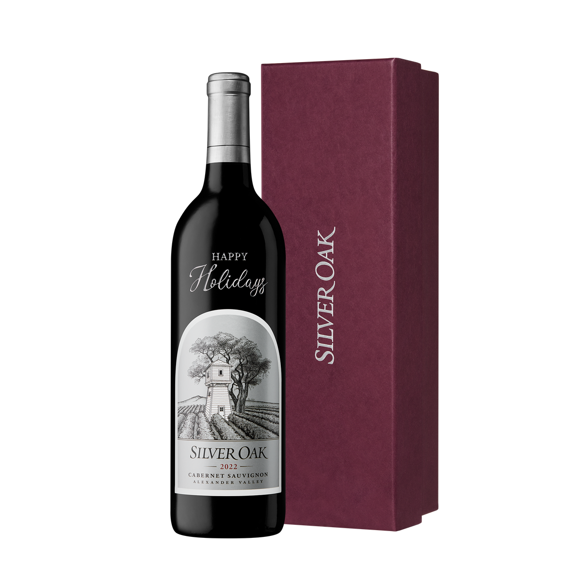 A bottle of Silver Oak Alexander Valley etched and hand painted with the message Happy Holidays, beside a burgundy gift box
