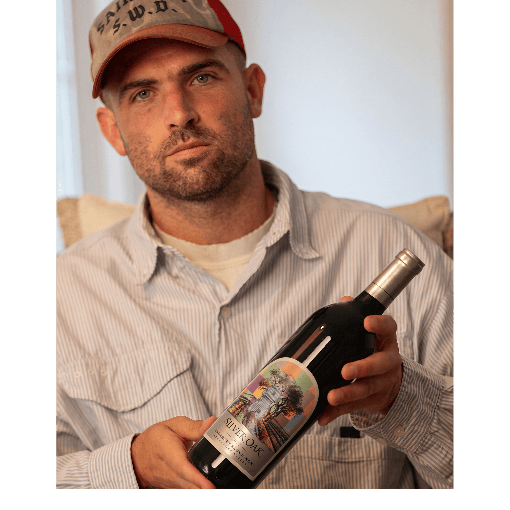 Artist Sean Wotherspoon holds the bottle of Silver Oak Alexander Valley Cabernet with his custom-designed label