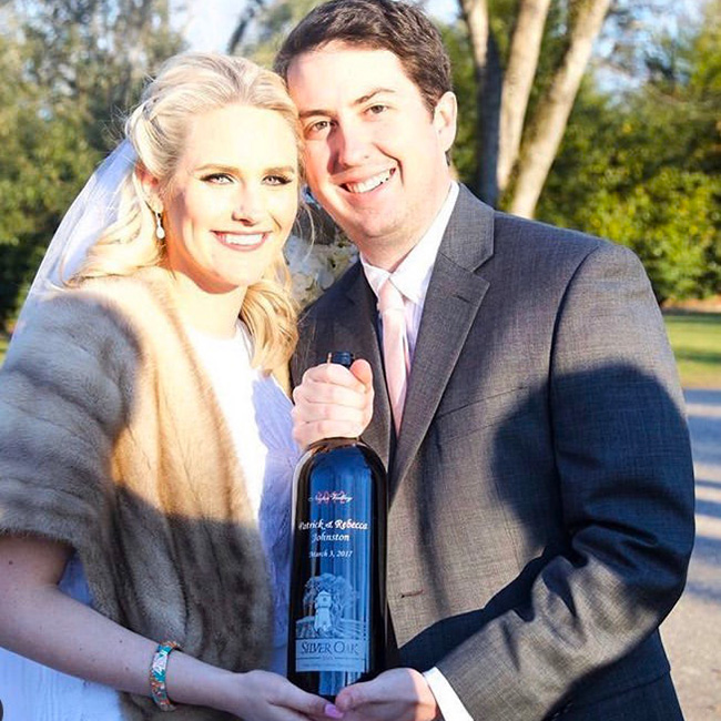 Becca and Patrick holding their custom-etched Silver Oak wedding magnum